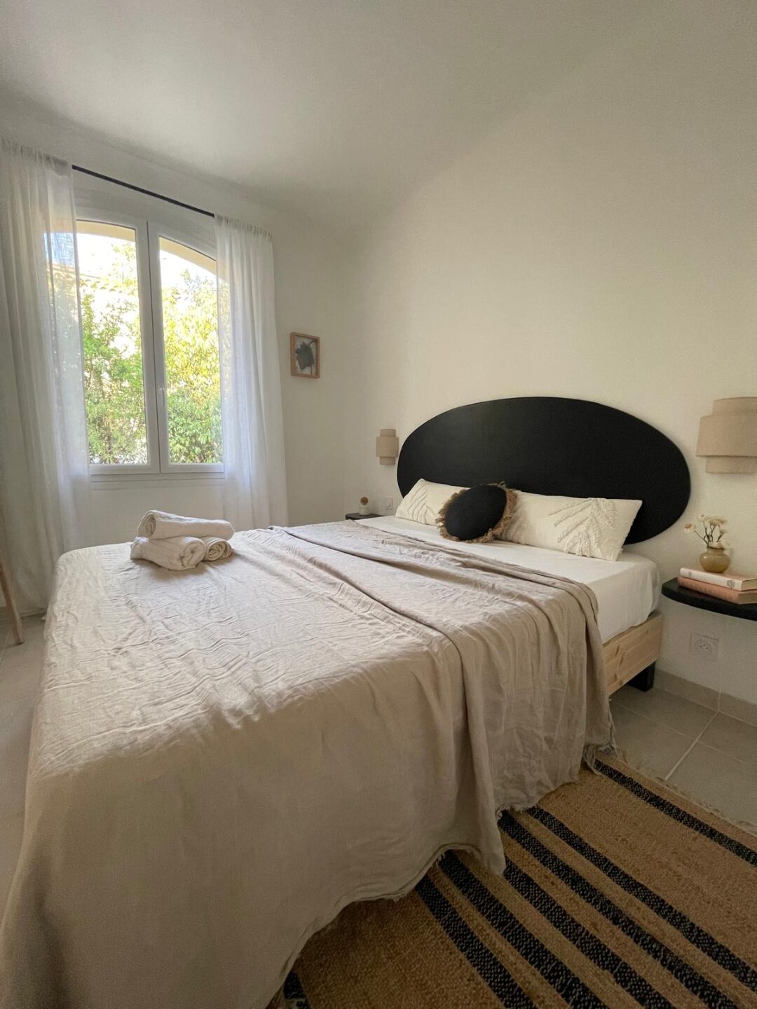 Schlafzimmer mit rundem schwarzen Kopfteil