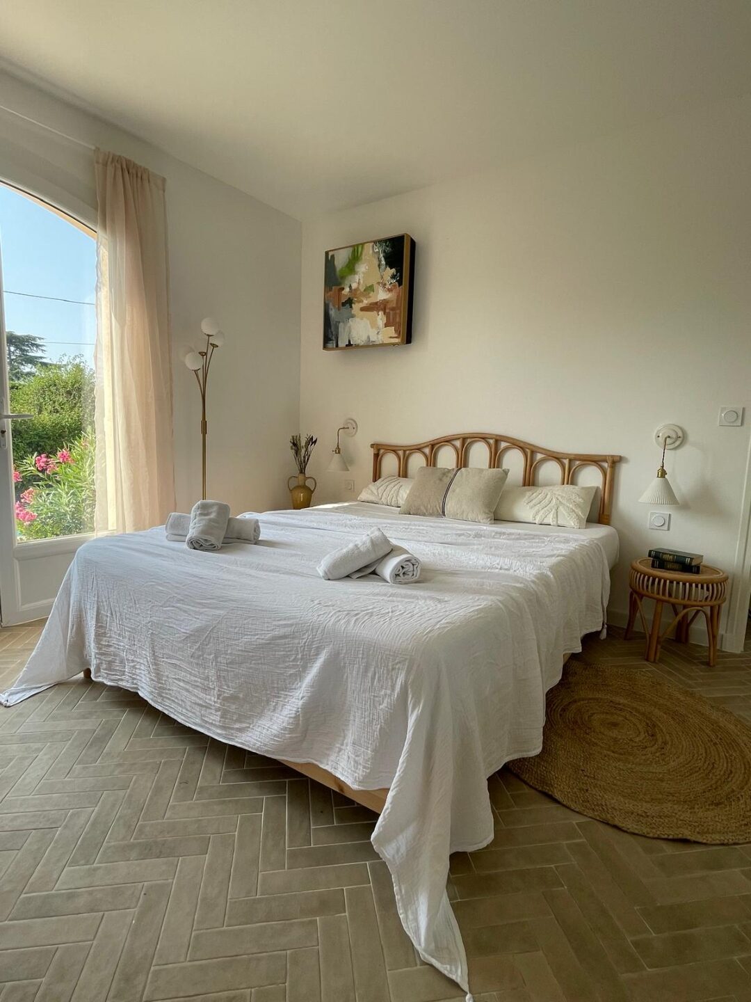Schlafzimmer mit weißer Bettwäsche und Blick in den Garten