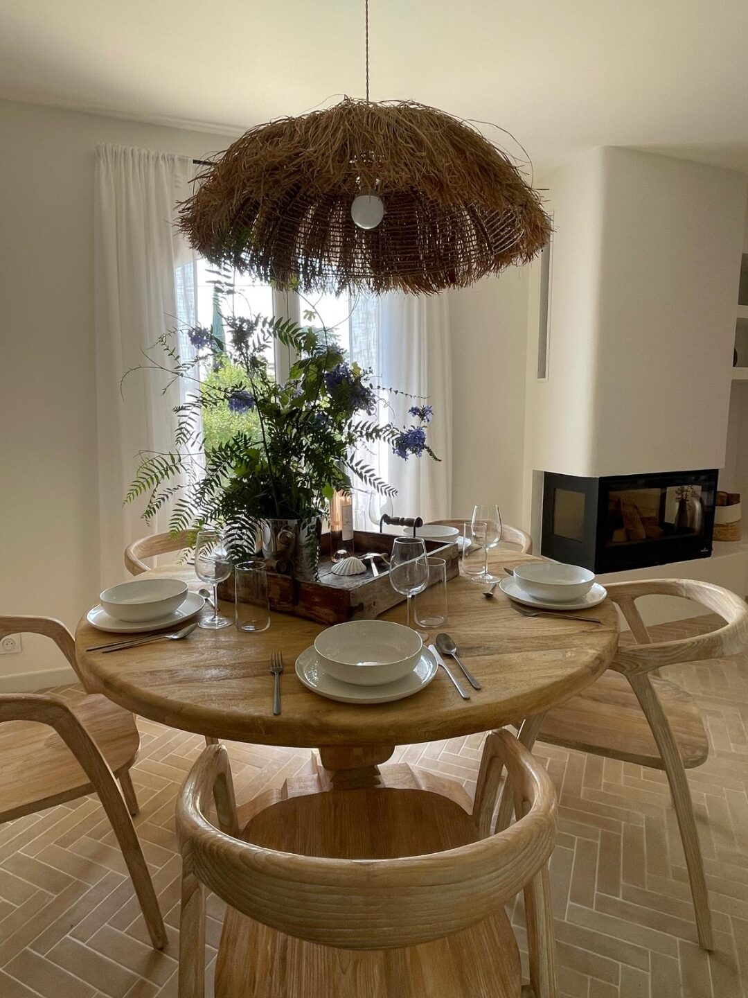 Essbereich mit Rattan-Hängelampe und Kamin
