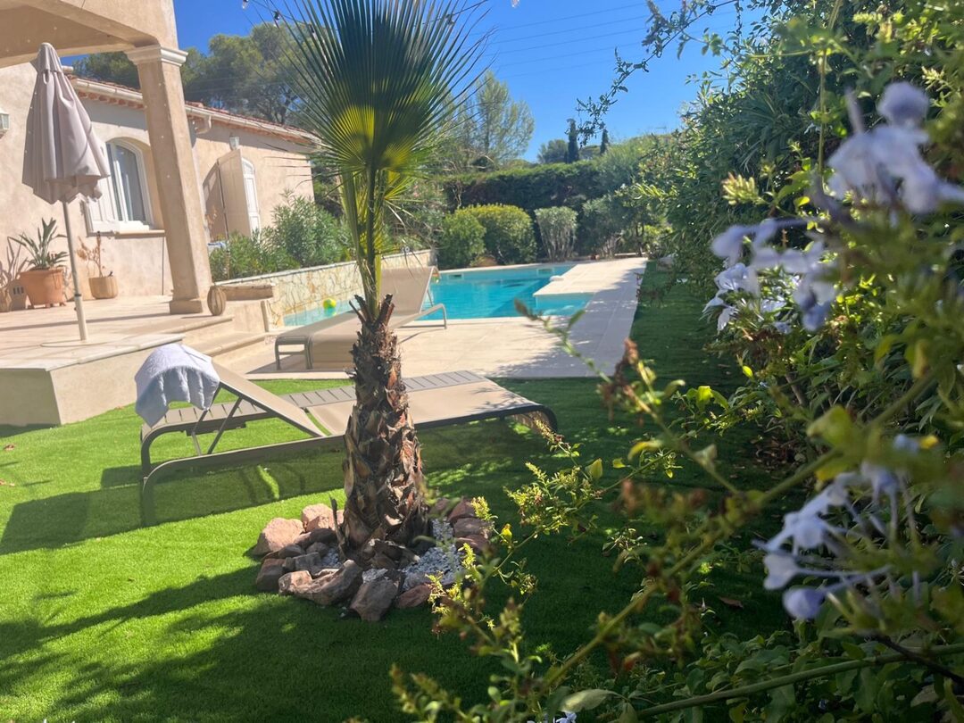 Privater Pool umgeben von Palmen und mediterranem Garten